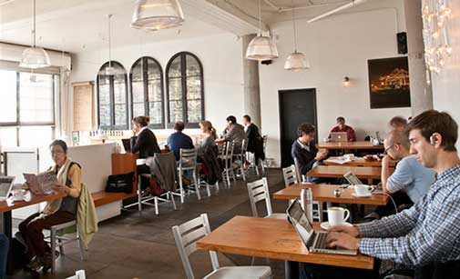 Gente conectada al wifi en una cafetería