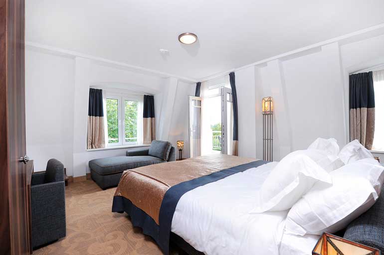 Una acogedora cama con textiles de Resuinsa en el Gran Hotel Ter Duin (Holanda)