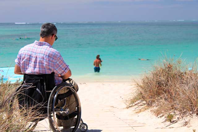 Persona con silla de ruedas en una playa 