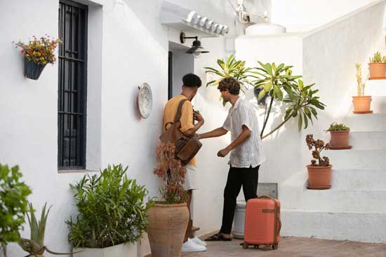 Profesionalhoreca. jóvenes huéspedes entrando a un apartamento. Alquileres vacacionales